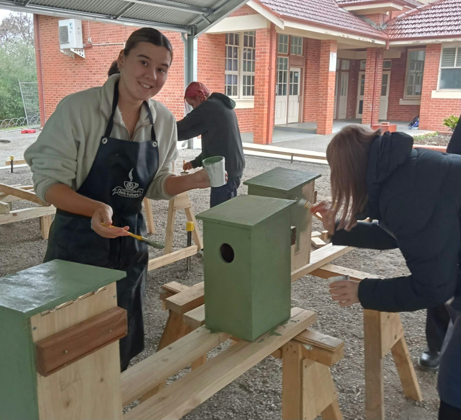 Students paint the nesting boxes to blend into the natural environment, ready for installation (Image source : Ken Beasley)