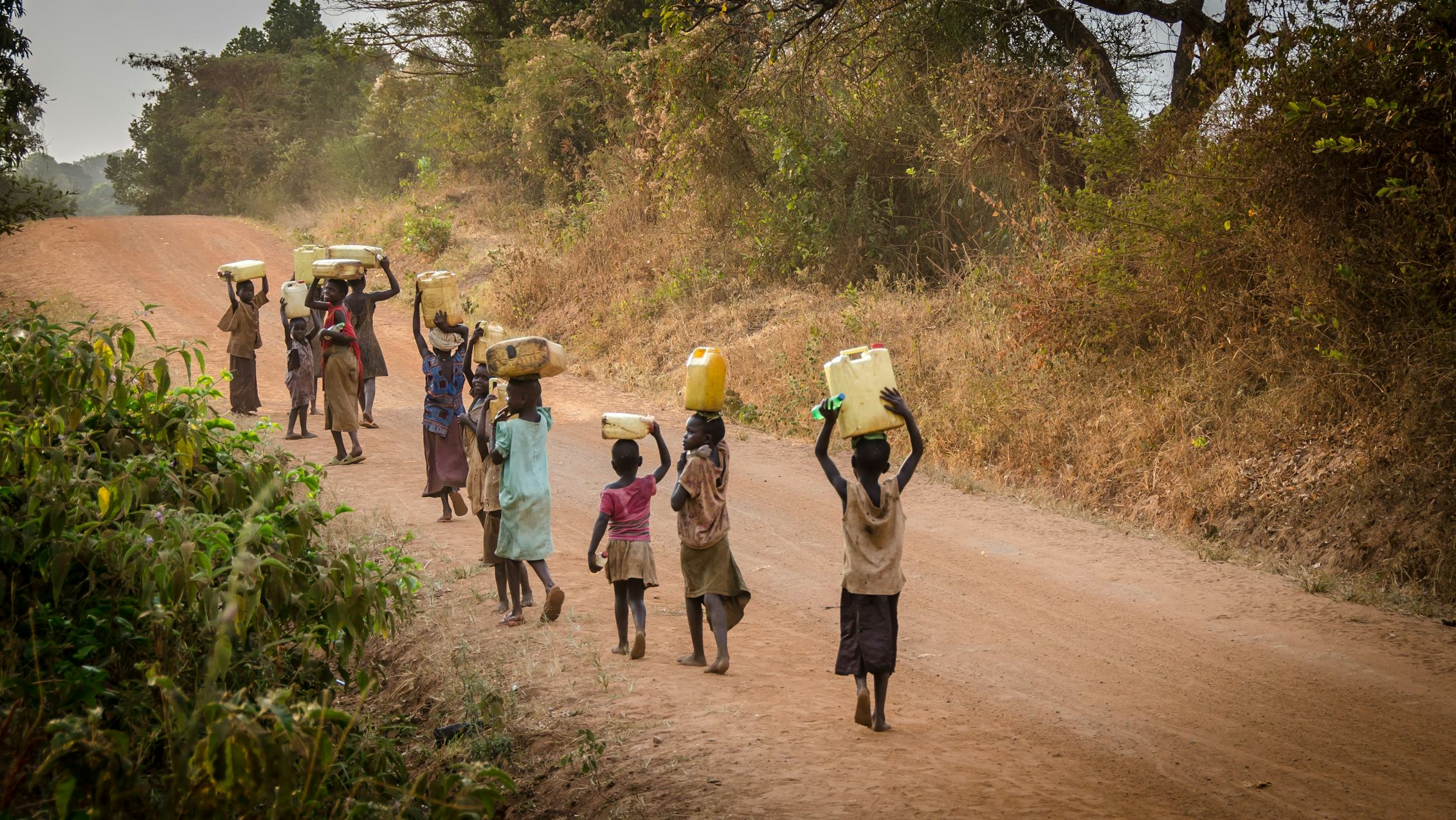 People travelling a distance to collect water in areas struck with water shortages (Image source: Unsplash)